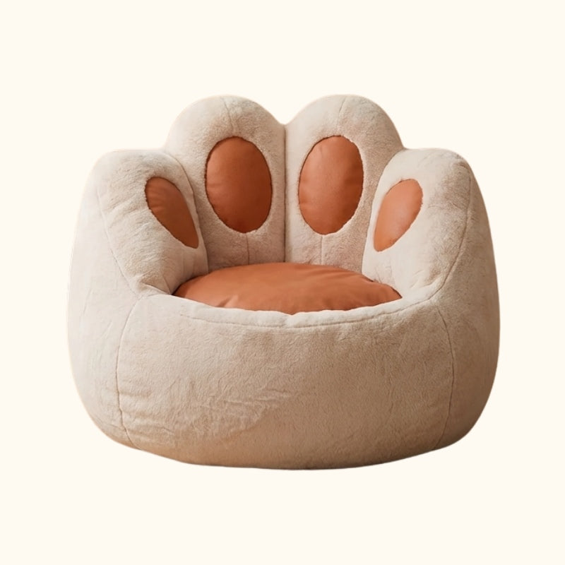 Cute bean bag chair shaped as cat paw with beige plush fabric and caramel colored toe pads on white background