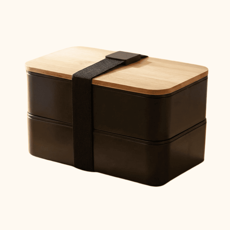 Two-tier dark brown bento box containers japanese style with bamboo lid and black elastic strap on clean white background