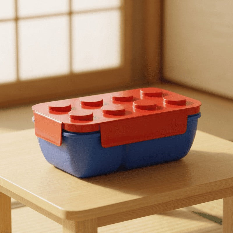 Compact bento box japanese with red studded lid and blue container resting on wooden table beside traditional shoji window catching morning rays