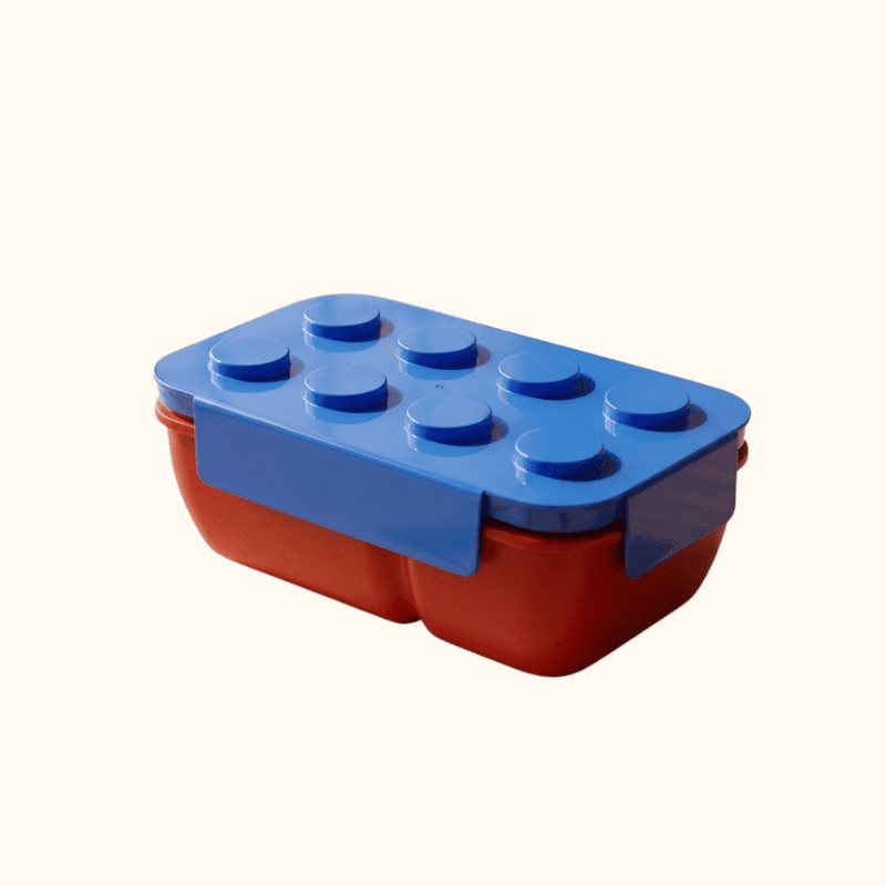 Colorful blue and red bento snack box japanese design with raised Lego studs on neutral white background