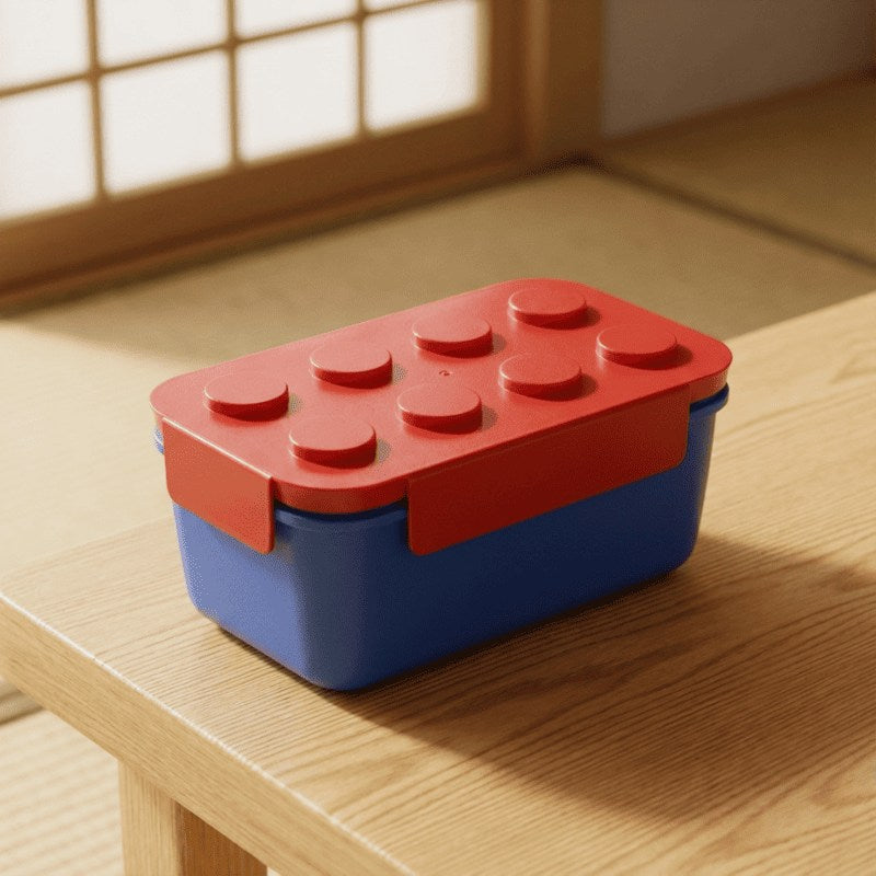 Spacious big bento box japanese featuring coral Lego lid and navy base on natural wood table in serene tatami room with soft lighting