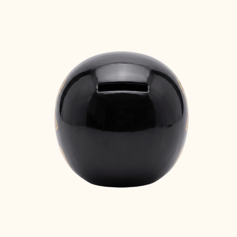 Rear view of a black Japanese Daruma doll with a glossy finish and a narrow coin slot.