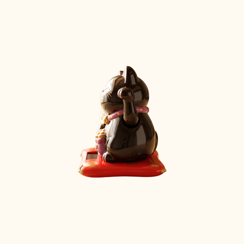 Black Maneki Neko Cat Japanese lucky cat, side view with glossy ceramic finish, raised paw and pink collar