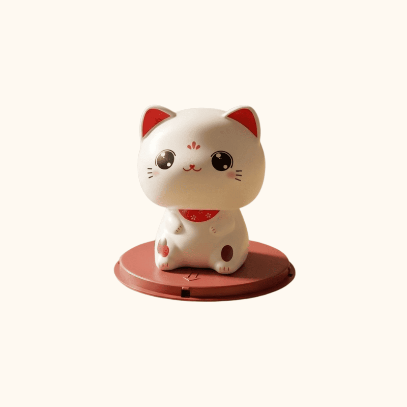 White cat good luck maneki neko with open eyes and red accents sitting on terracotta solar base on clean neutral background