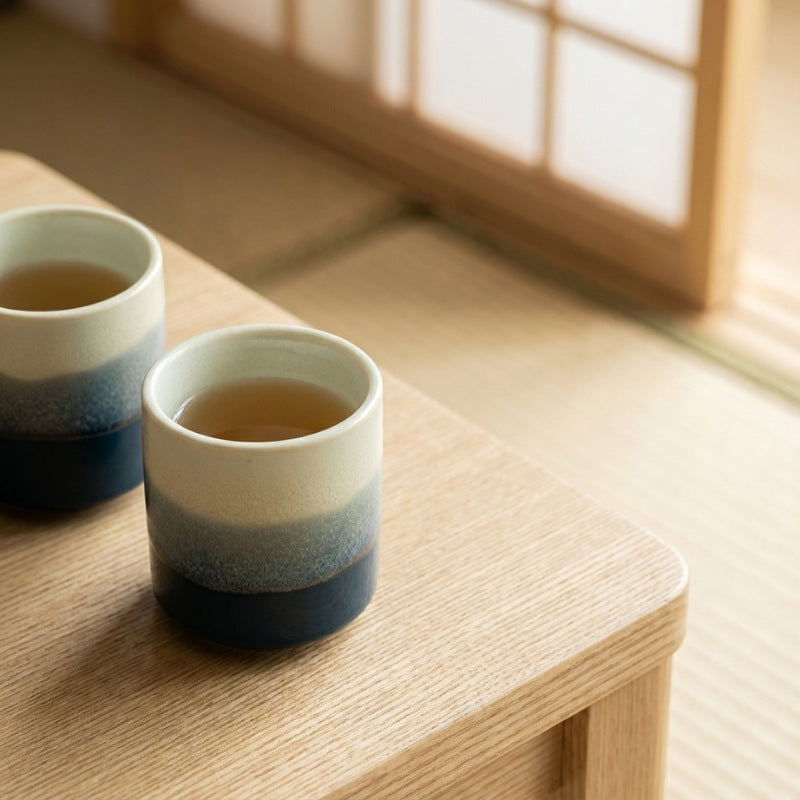 Ceramic tea cup japanese pair with mountain mist gradient on wooden table near bright shoji window