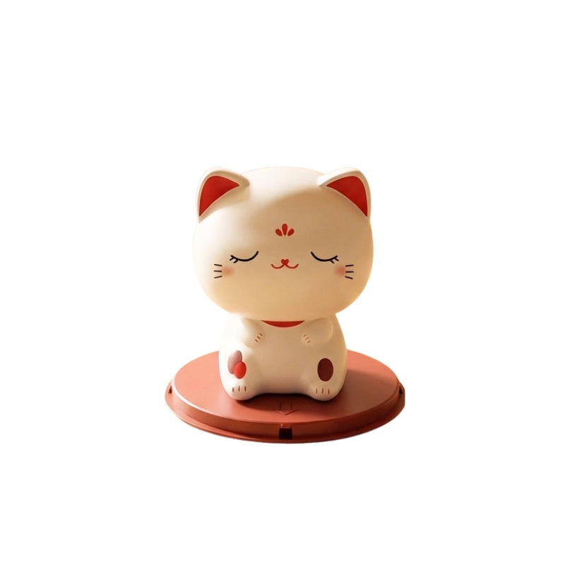 Peaceful cute japanese maneki neko with closed eyes in meditation pose on terracotta base displayed on white background