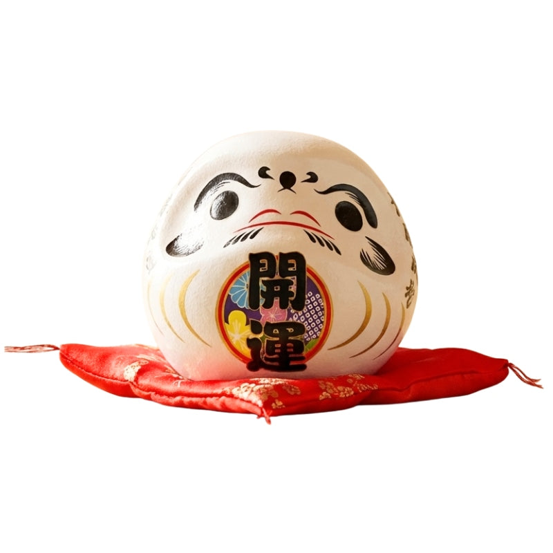 Harmony symbol daruma doll kanji japanese in pure white ceramic with traditional calligraphy details displayed on red floral cushion against white background