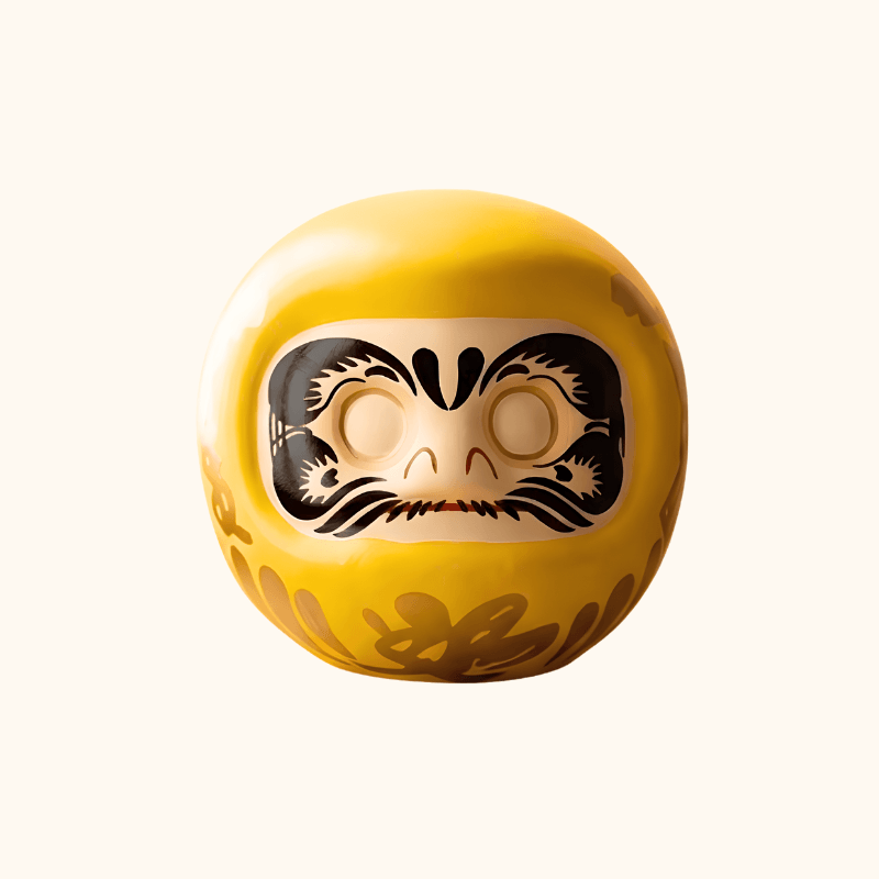 Bright yellow Daruma doll inspired by Japanese tradition, featuring blank eyes, an expressive face and gold decorative symbols.