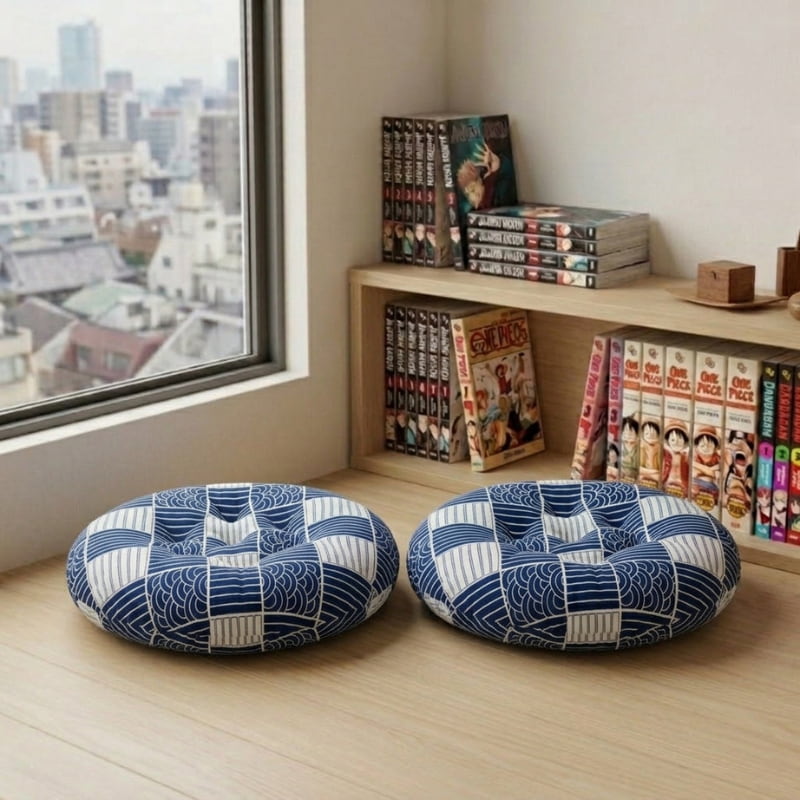 With matching wave patchwork in blue, this Japanese cushion pair rests on the floor near a manga bookshelf