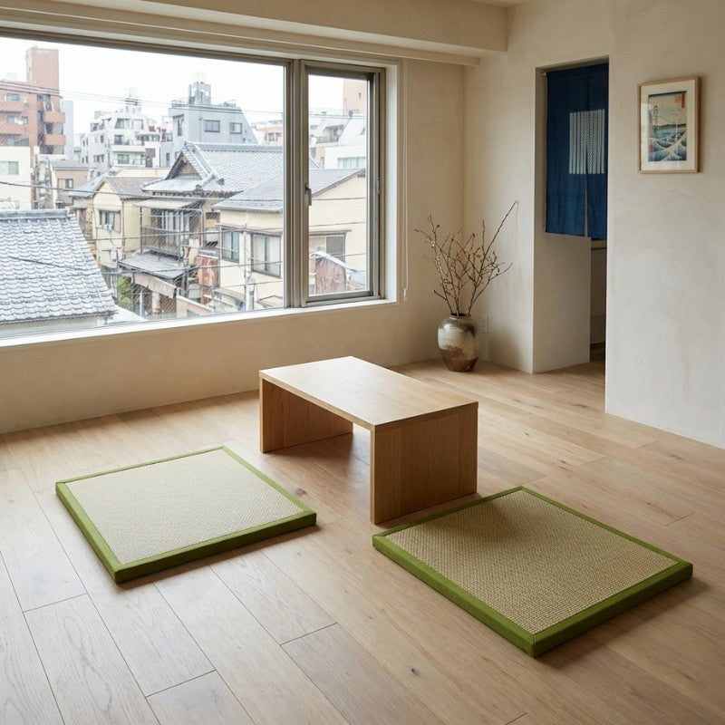 Floor japanese mat pair in green borders with natural rattan beside wooden table near urban window with noren and ukiyo-e art