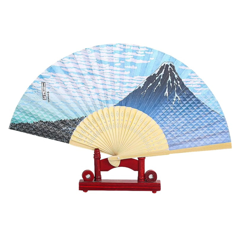 Classic folding fan japanese traditional featuring Mount Fuji blue wave pattern displayed on red wooden stand with natural bamboo frame