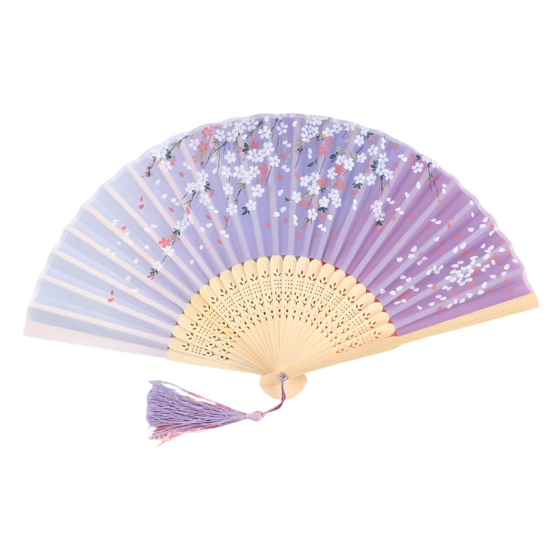 Lavender folding fan paper japanese with scattered white cherry blossoms decorative bamboo carving and purple tassel on white background