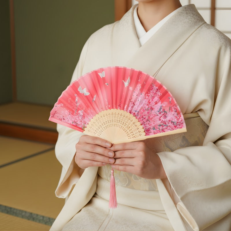Person in cream kimono holding hand fan japanese with vibrant pink sakura pattern and butterflies in traditional tatami room interior