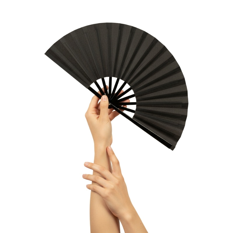 Refined japanese big fan in matte black held with both hands against minimalist white backdrop showcasing graceful folding design