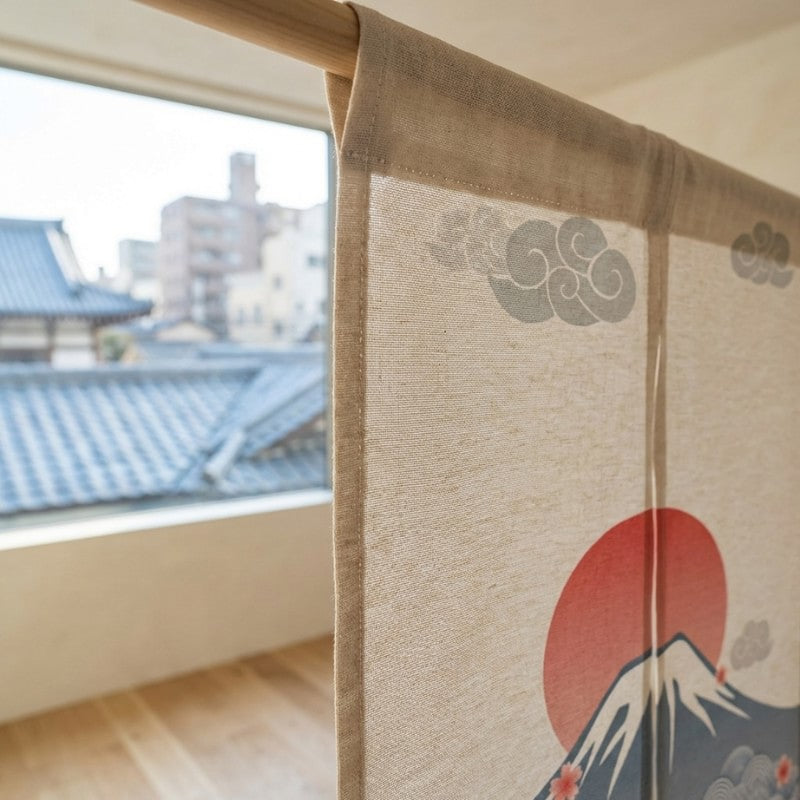 Close-up of japanese curtain noren texture showing Mount Fuji red sun and scrolling cloud motifs on natural linen fabric hanging on wooden rod with traditional Kyoto rooftop view