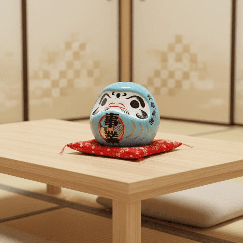 Calming japanese daruma doll blue with traditional characters placed on red ceremonial cushion atop low wooden table in minimalist tatami floor setting