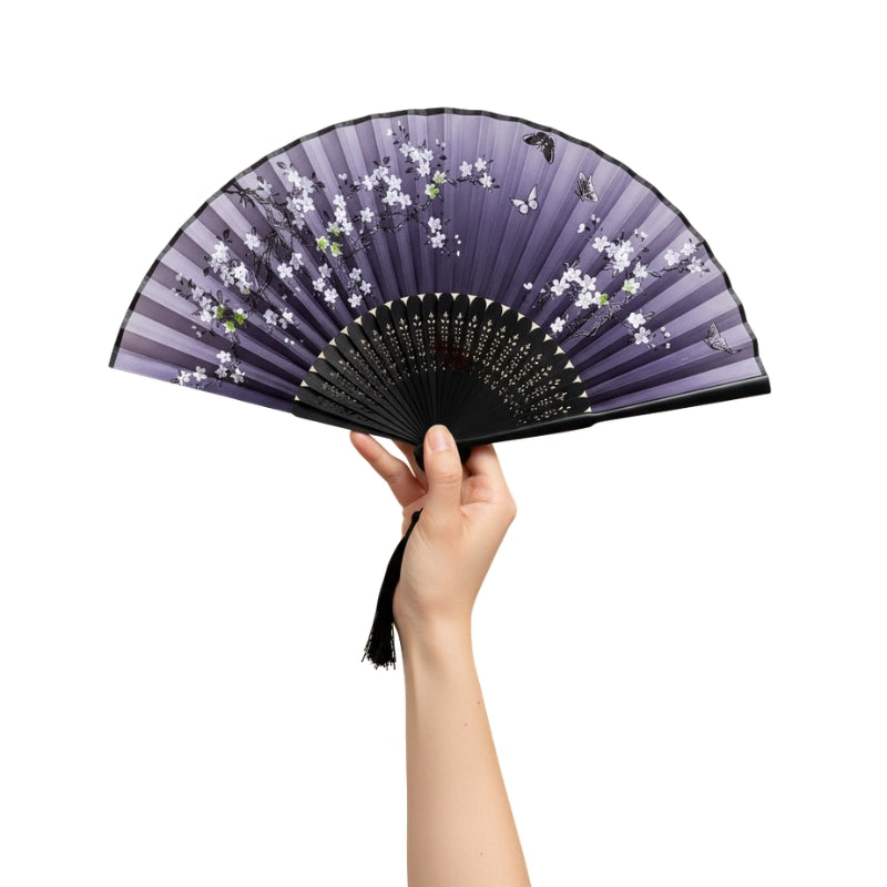 Elegant japanese fan vintage design in purple gradient with white cherry blossoms butterflies and black lacquered frame held against white background