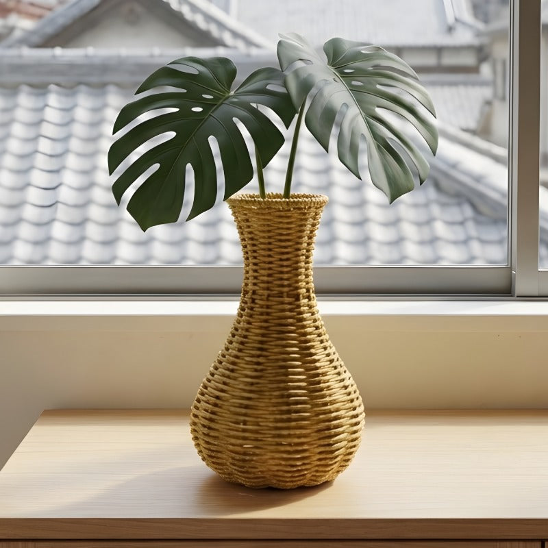 Japanese flower vase made of hand woven natural material, displayed near a window with soft daylight.