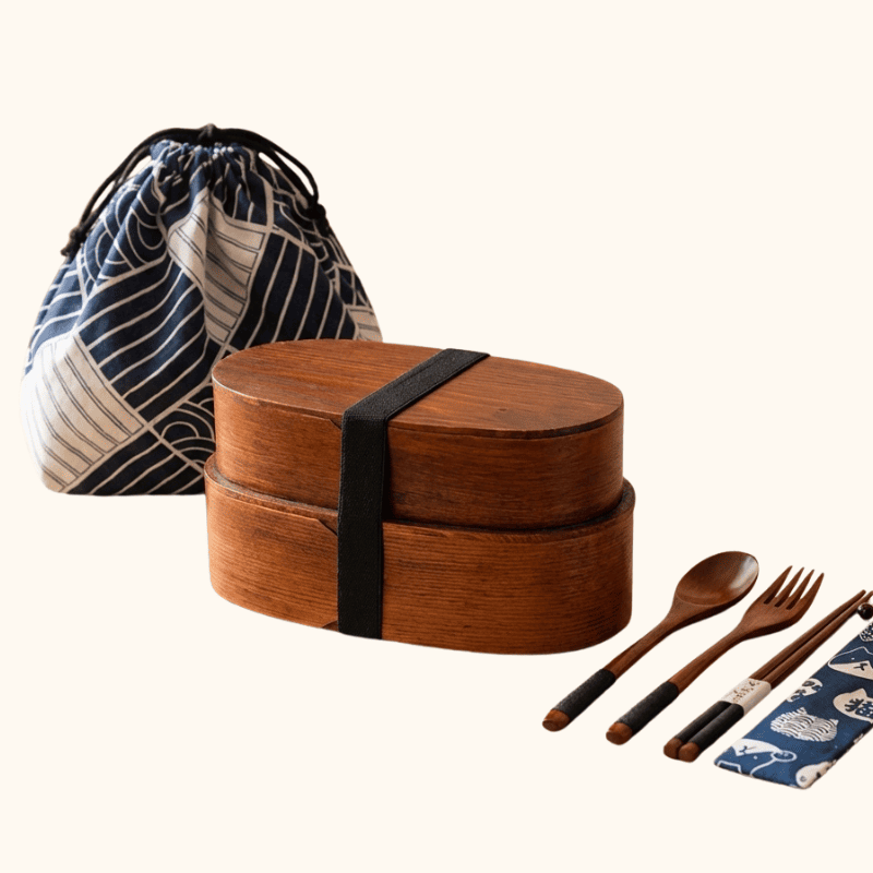 Stackable dark wood japanese traditional bento box with geometric patterned carrier bag and complete wooden utensil set on clean background
