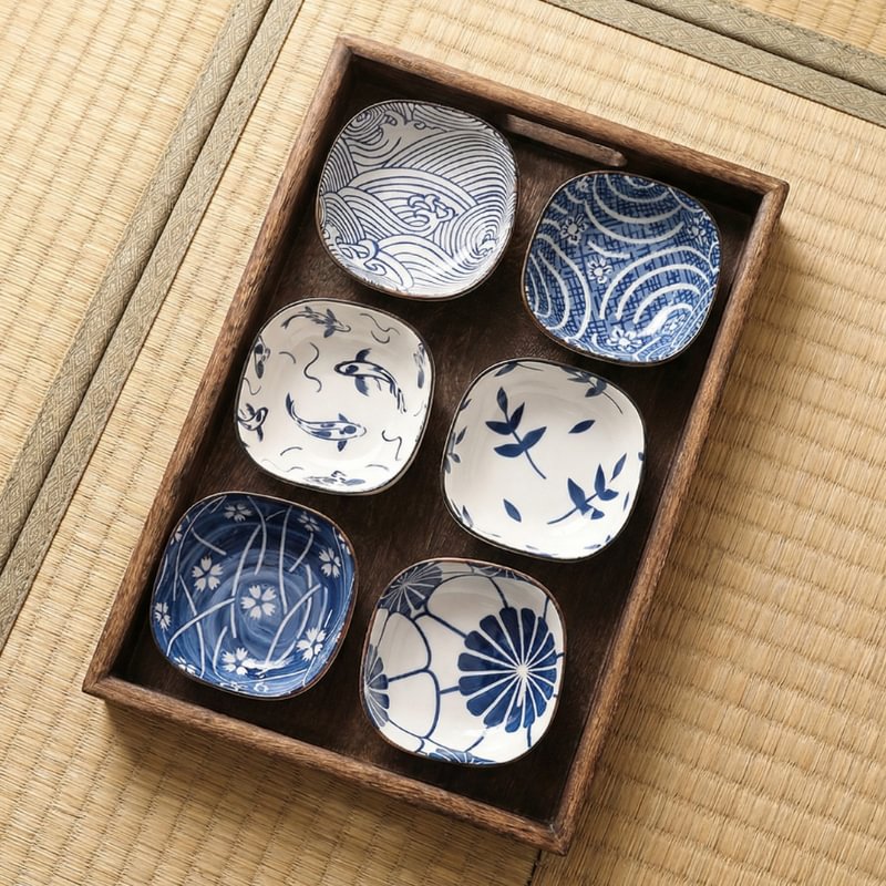 Kobachi bowl collection of six porcelain dishes featuring koi fish, bamboo leaves and geometric designs in rustic wood box on tatami mat