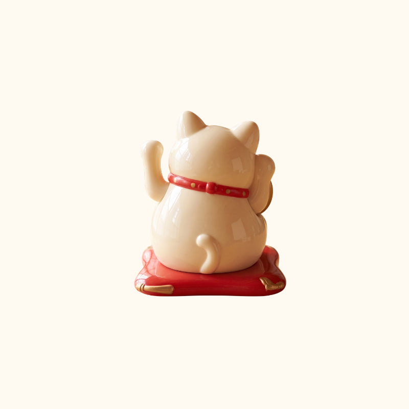 Cream Maneki Neko Cat Japanese lucky cat figurine, rear view with raised paws, red collar and gold accents