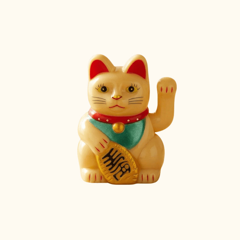 Golden Maneki Neko Japanese figurine holding a traditional gold coin, with a raised waving paw and red collar.