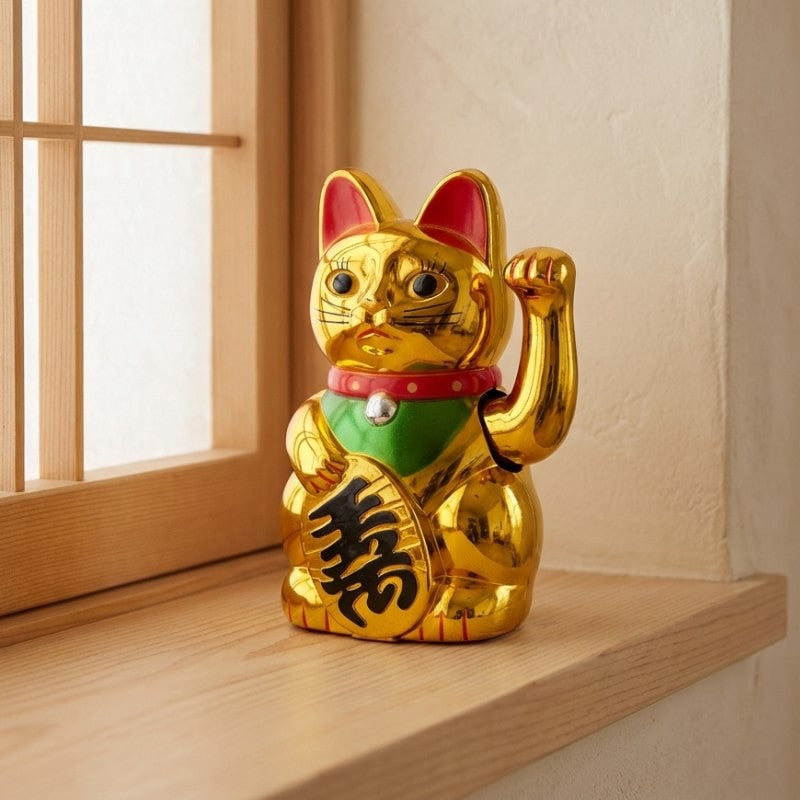 Traditional maneki neko statue gold cat with raised paw positioned on wooden windowsill near bright shoji screen in minimalist setting