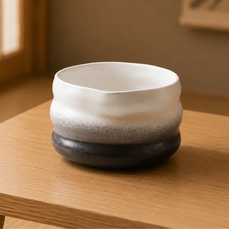 Matcha ceramic bowl with white-to-dark gradient and ribbed organic shape on a light wood table in a softly lit Japanese room
