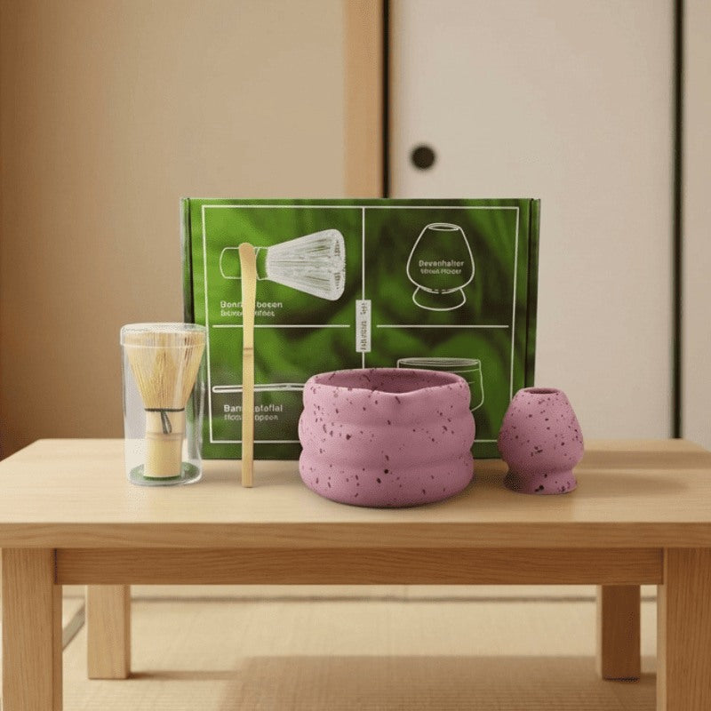 Pink speckled matcha gift set japanese style with bamboo whisk displayed on wooden table near traditional sliding door in warm ambient light