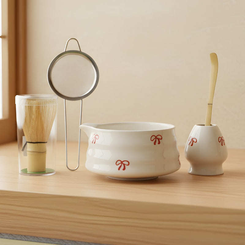 Matcha green tea set white porcelain bowl with red bows bamboo chasen whisk sieve and scoop on wooden shelf in Japanese interior