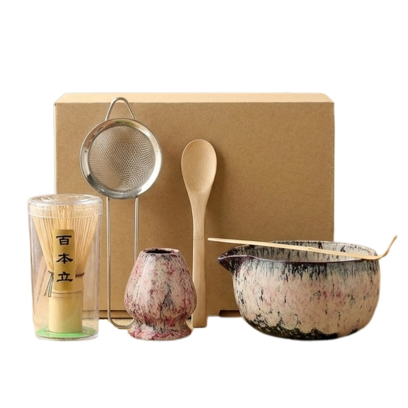 Delicate pink and white matcha tea japanese set with speckled ceramic bowl and bamboo accessories on neutral studio background