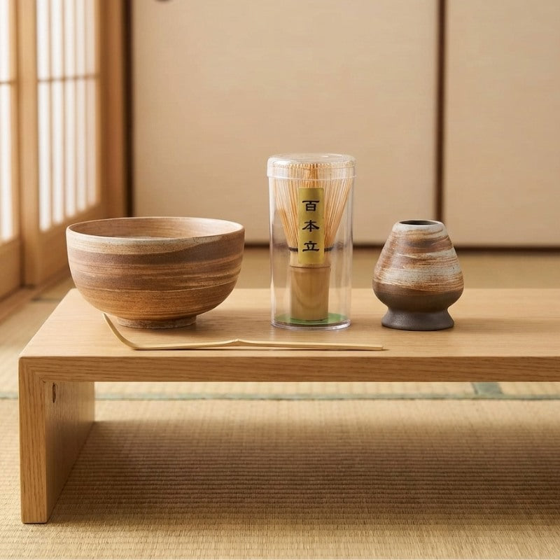 Complete matcha tea set ceremonial in earthy brown tones on wooden shelf with natural light from shoji window
