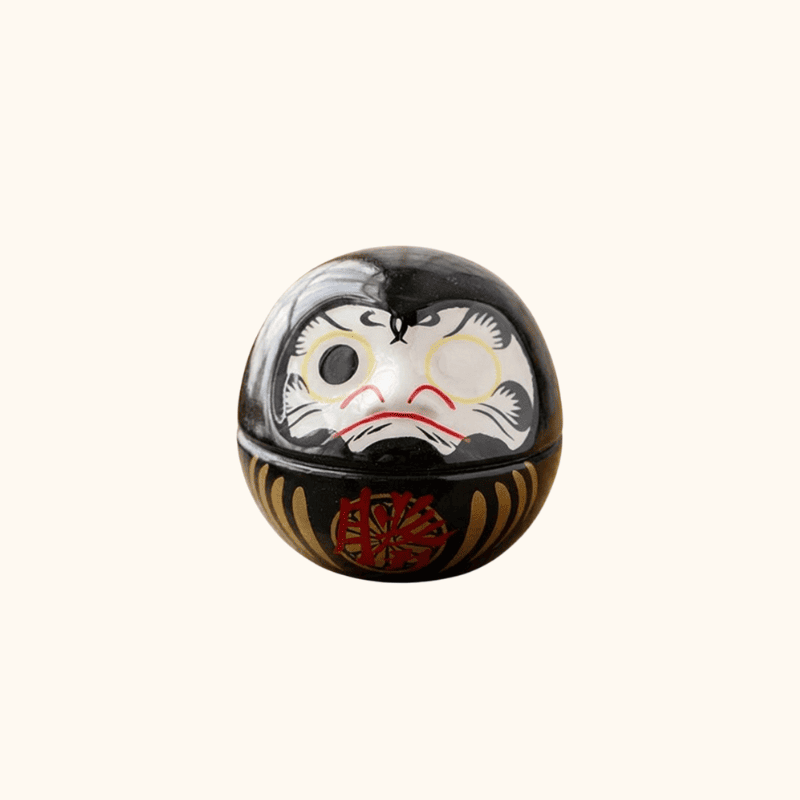 Mini daruma black featuring glossy finish and traditional facial features with prosperity kanji on clean white background