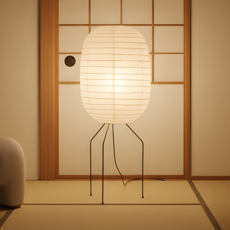 Illuminated nugochi akari lamp with warm glow through ribbed rice paper oval shade on tatami floor near traditional shoji screen