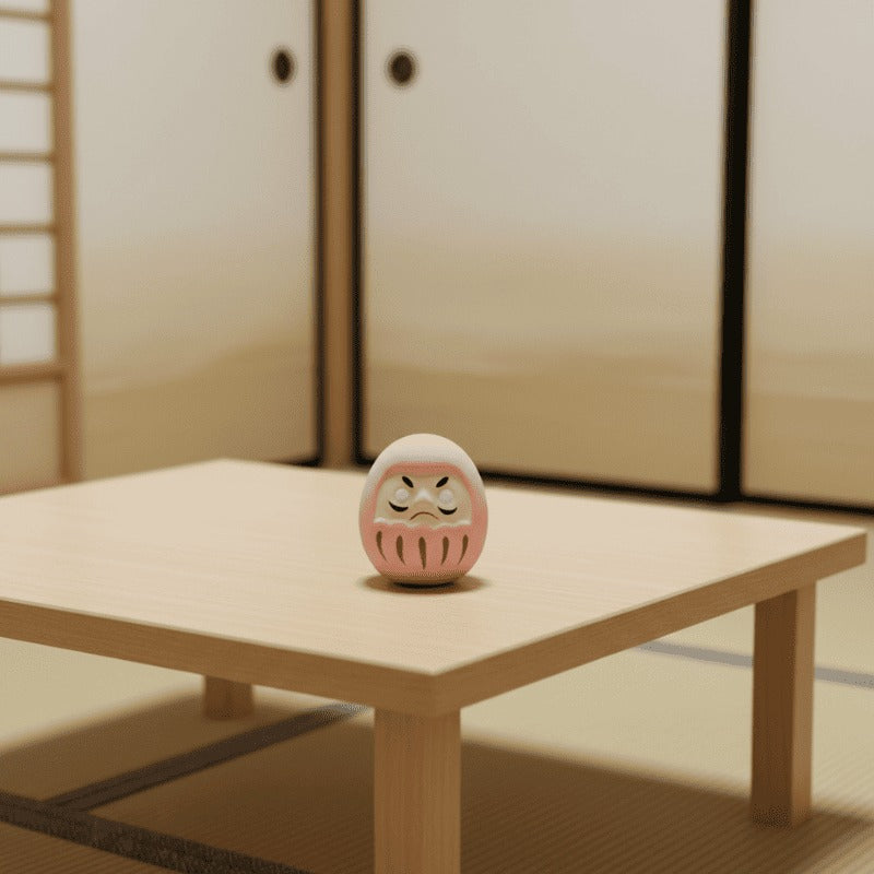 Soft pink daruma japanese doll with traditional facial features displayed on low wooden table in minimalist tatami room with shoji screen backdrop