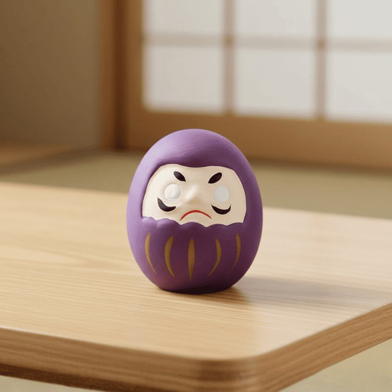Vibrant purple daruma with blank eyes and gold accents resting on wooden surface near shoji window in warm ambient light