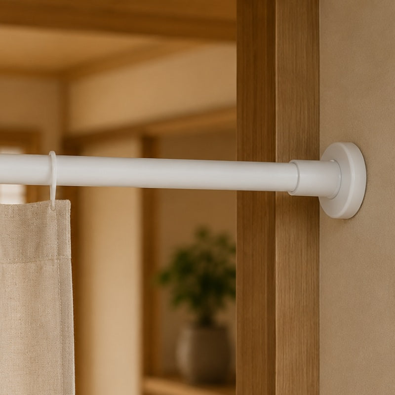White tension rod for noren mounted between a wooden door frame with a linen curtain hanging from a ring, Japanese-style interior in the background