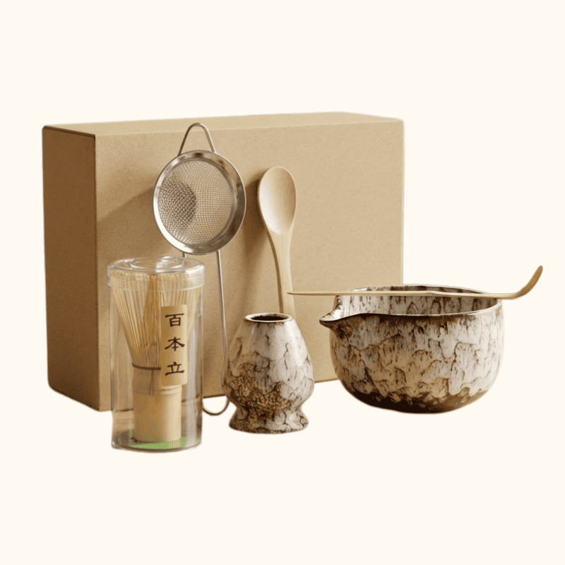 Complete set for matcha japanese with brown speckled ceramic bowl and six bamboo tools on clean white studio background