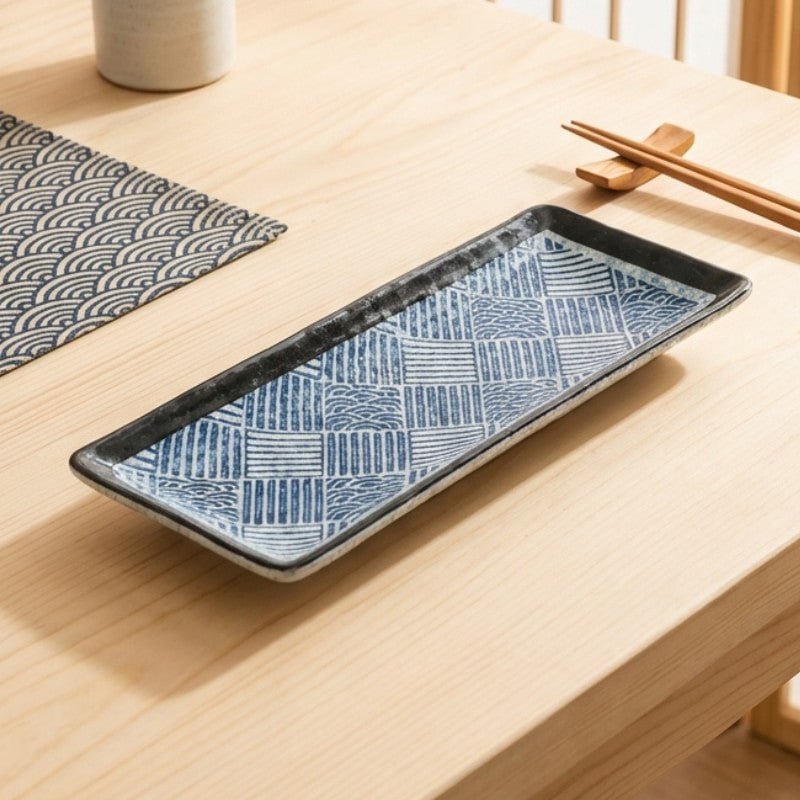 Elegant sushi plate decoration with blue basketweave design and black borders on natural wood table with chopsticks