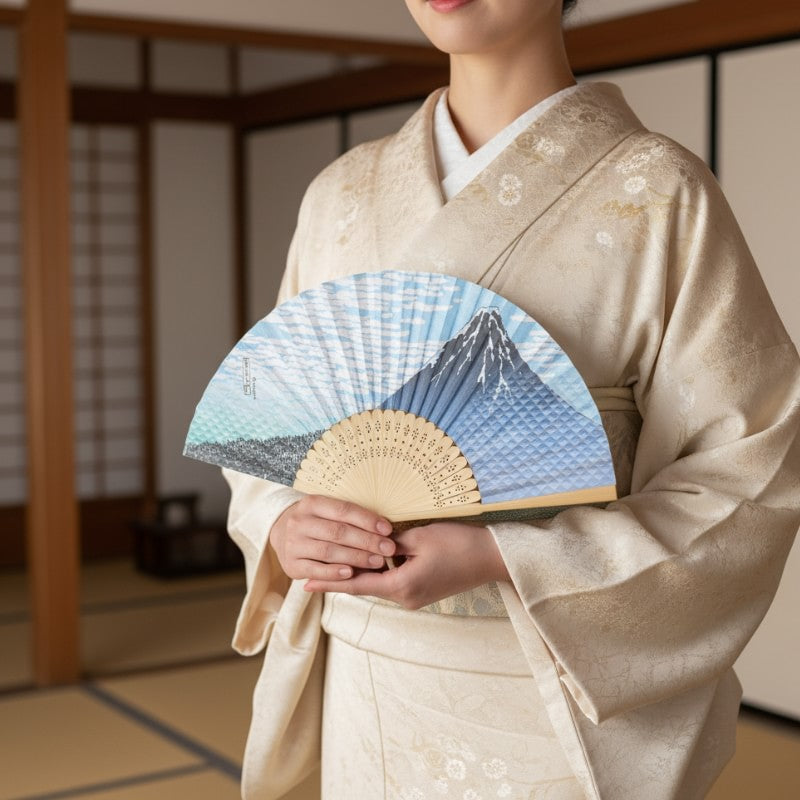 Refined traditional japanese folding fan featuring Mount Fuji design held by person wearing beige kimono in serene traditional interior with tatami mats
