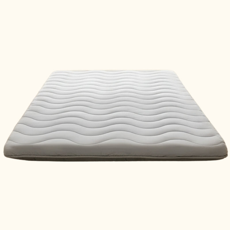 Comfortable white japanese futon with flowing wave pattern quilting displayed on clean white background showing traditional craftsmanship