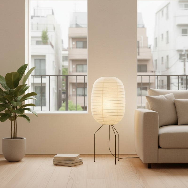 Elegant akari nugochi lamp featuring soft oval rice paper cocoon on black metal legs beside beige sofa in contemporary minimalist living room