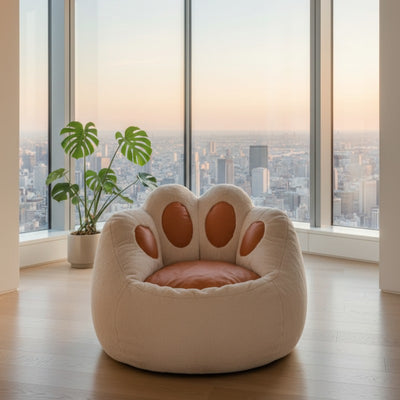 Cute cat paw bean bag chair in beige fleece with caramel toe pads by floor to ceiling windows overlooking city skyline