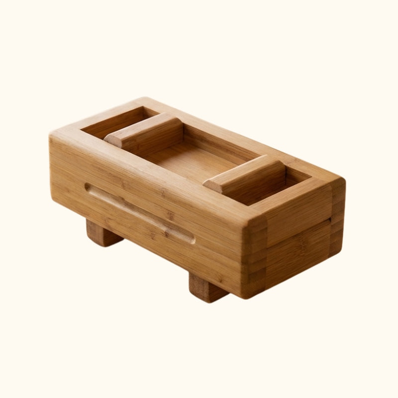 Handcrafted bamboo sushi mold with rectangular press frame removable lid and four small feet displayed on clean white background