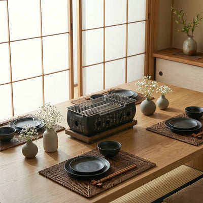 Barbecue grill Japanese style with calligraphy decoration on wooden dining table surrounded by black ceramic plates and traditional shoji doors