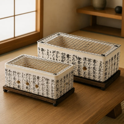 Bundle of two Japanese barbecue grills in small and large sizes with white ceramic kanji calligraphy bodies and steel mesh grills on dark wood stands on a wooden surface in a traditional tatami room