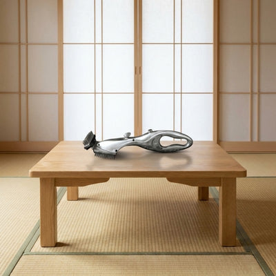 Stainless steel bbq brush grill displayed on traditional Japanese chabudai low table with shoji paper screens in minimalist tatami room