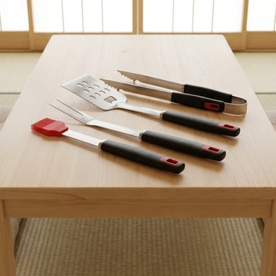 Four-piece bbq tool set with stainless steel spatula tongs fork and silicone basting brush on low chabudai table in Japanese tatami room with shoji screens