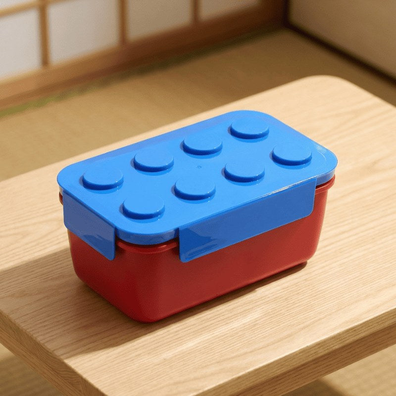 Kid-friendly big bento snack box with blue Lego lid resting on wooden table with tatami mat in minimalist Japanese interior