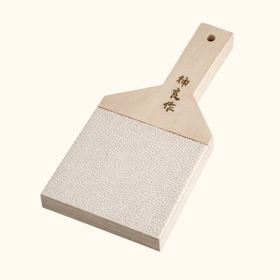Authentic big wasabi grinder with Japanese kanji calligraphy and sharkskin texture surface on white background